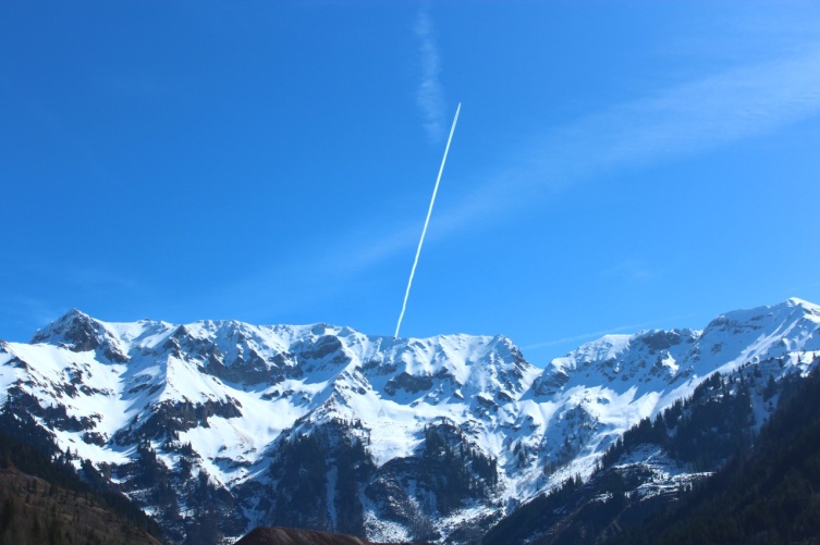 Ein Flugzeug fliegt über einen Berg